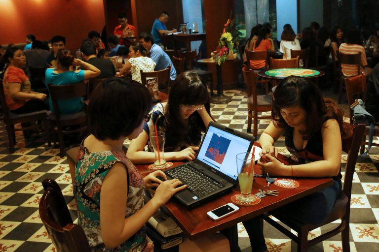 FOR CHRIS BRUMMITT STORY - FILE - In this May 14, 2013 photo, three young Vietnamese women use a laptop and smart phones to go online at a cafe in Hanoi, Vietnam. Vietnamese pro-democracy activists and bloggers are battling a gathering campaign of blocking, hacking and spying by a shadowy pro-government army of cyber warriors. Although they canât prove it, activists and analysts strongly suspect the Vietnamese state is involved in the campaign, which is hampering the countryâs democracy movement. (AP Photo/Na Son Nguyen, File)