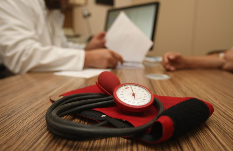 A doctor speaks to a patient as a sphygmomanometer, or blood pressure meter, lies on his desk on September 5, 2012 in Berlin, Germany. (Photo by Adam Berry/Getty Images)