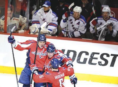 Nick Wass/AP
Mike Green, center, scored the game-winning goal with 5:48 to play Saturday as the Caps evened their series with the Rangers.