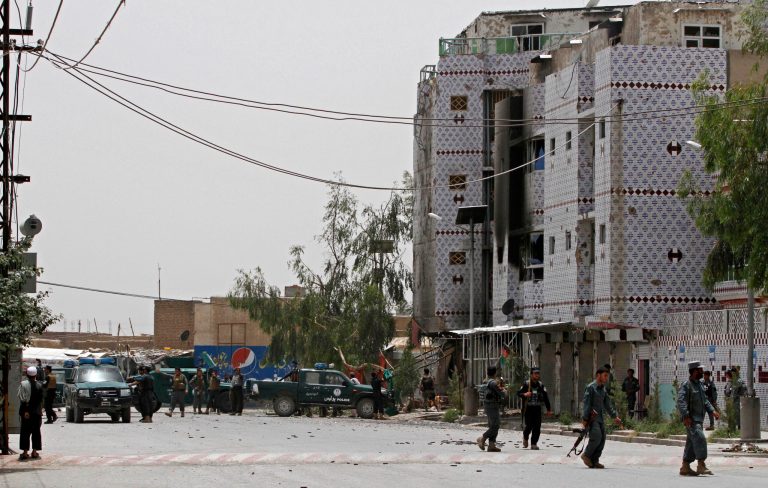 Afghan forces gather during clashes with Taliban fighters in Kandahar, southern Kabul, Afghanistan, Sunday, June 15, 2014. In the southern Kandahar province police said they raided a building on Sunday that had been occupied by the Taliban the day before, setting off clashes in which police shot dead two would-be suicide bombers but were unable to prevent another two from blowing themselves up, killing several policemen and wounding many. (AP Photo/Allauddin Khan)