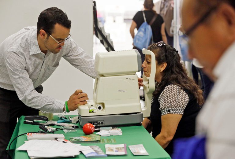 Rosa Guerra, 52, right, gets a free eye exam during a health week event held at the Mexican Consulate in Los Angeles. (AP Photo/Damian Dovarganes, File)