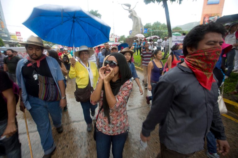 Demonstrators protest the disappearance of 43 students from the Isidro Burgos rural teachers college, in Acapulco, Guerrero state, Mexico, Friday, Oct. 17, 2014. Investigators determined that 28 sets of human remains recovered from a mass grave discovered last weekend outside Iguala, in Guerrero state, were not those of any of the youths who haven't been seen since being confronted by police in that city Sept. 26. (AP Photo/Eduardo Verdugo)