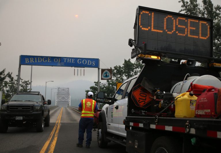 A barricade closes the Bridge of the Gods, spanning the Columbia River between Washington and Oregon states, near Stevenson, Wash., Wednesday, Sept. 6, 2017. The Eagle Creek fire continues to burn on the Oregon side of the river near the town of Cascade Locks, Ore. (AP Photo/Randy L. Rasmussen)