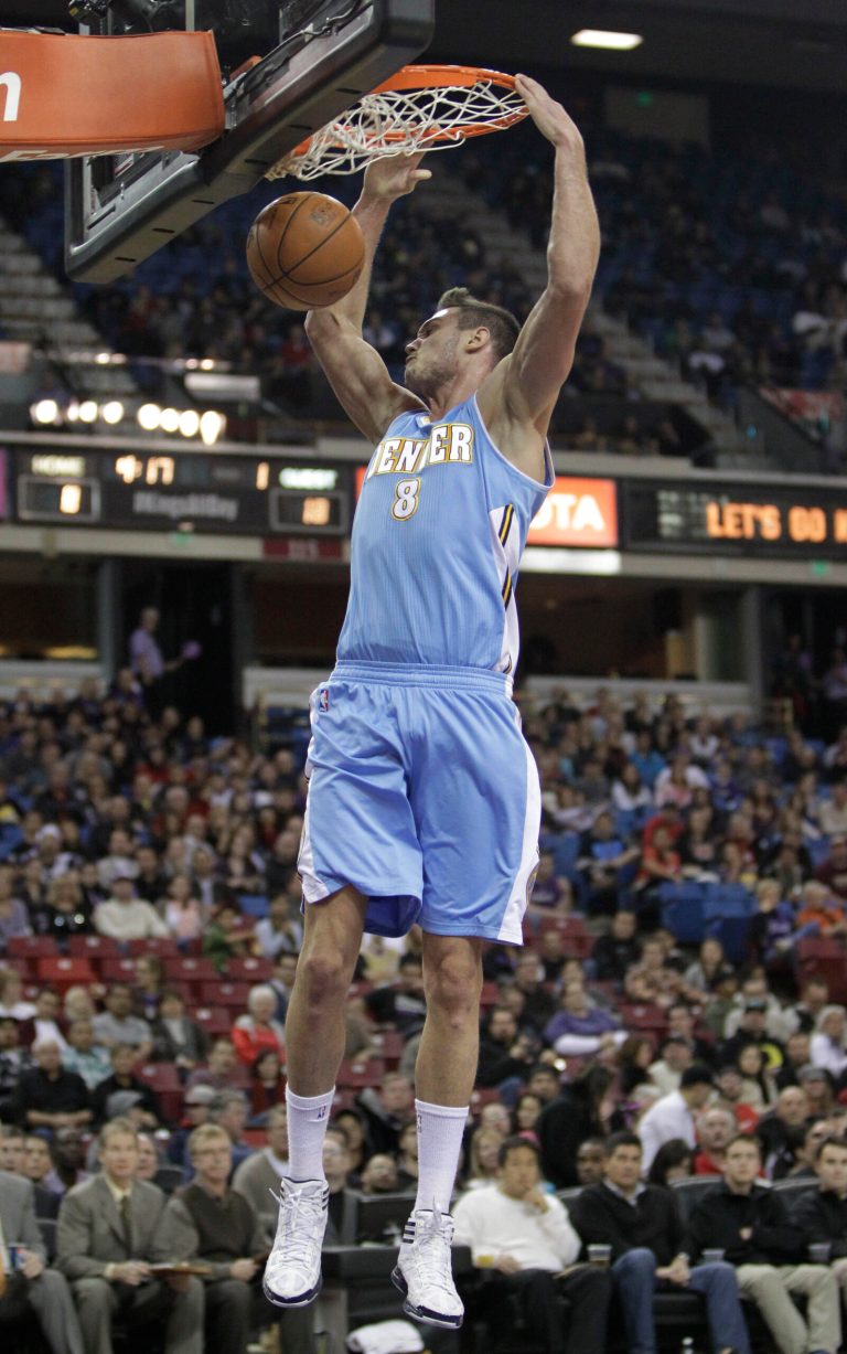   Denver Nuggets forward Danilo Gallinari, of Italy, hangs on the rim after stuffing against the Sacramento Kings during the first quarter of an NBA basketball game in Sacramento, Calif., Sunday, Dec. 16, 2012.(AP Photo/Rich Pedroncelli)  