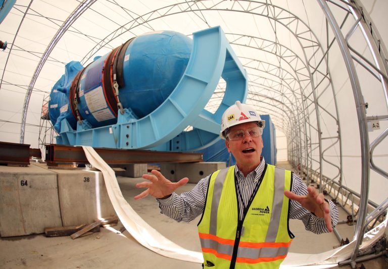In this Friday, June 13, 2014 photo, Buzz Miller, executive vice president of nuclear development at Southern Co., stands in front of the high-pressure vessel that will be used in a new nuclear reactor at Plant Vogtle power plant in Waynesboro, Ga. Before it started building, the nuclear industry promised its new generation of plants would be constructed using giant Lego-like modules that make building faster, cheaper and produce a higher-quality result. Instead, the Louisiana factory building these modules has failed to master quality control rules, stick to schedule or replicate the approved designs, adding time and significant cost to first-of-their-kind projects. (AP Photo/John Bazemore)