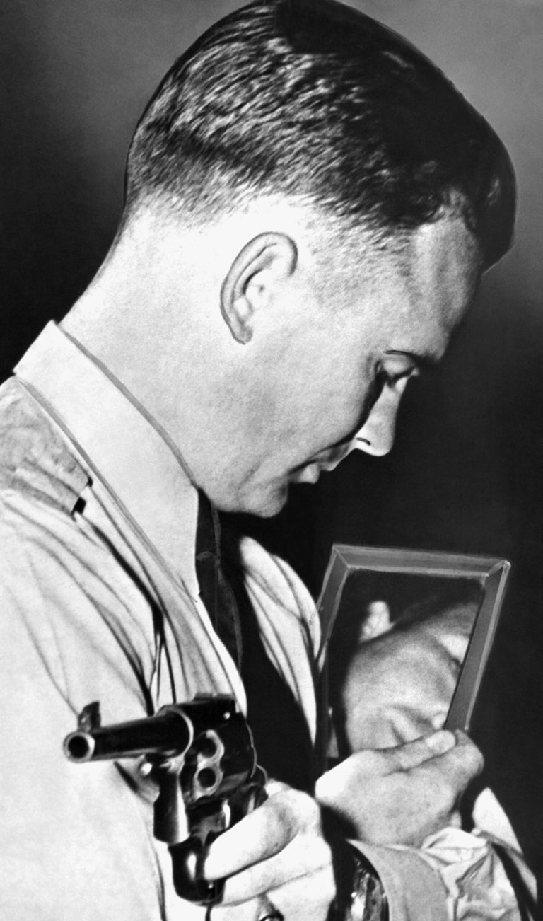 FILE - This Oct. 1937 file photo shows Federal Agent Walter Walsh during a demonstration of him as he takes aim in a mirror, in Quantico, Va. Walsh, the world's oldest living Olympian, has died. He was 106. USA Shooting says Walsh died Tuesday _ six days before his 107th birthday _ at his home in Arlington, Virginia. Walsh finished 12th in the men's 50-meter free pistol event at the 1948 London Olympics. He had already demonstrated his marksmanship working for the FBI and the Marine Corps. During the Depression, Walsh was instrumental in the capture and killing of several gangsters, including discovering the body of Baby Face Nelson and catching Arthur (Doc) Barker.  Walsh spent more than 20 years as a shooting instructor before his retirement in 1970. (AP Photo, File)