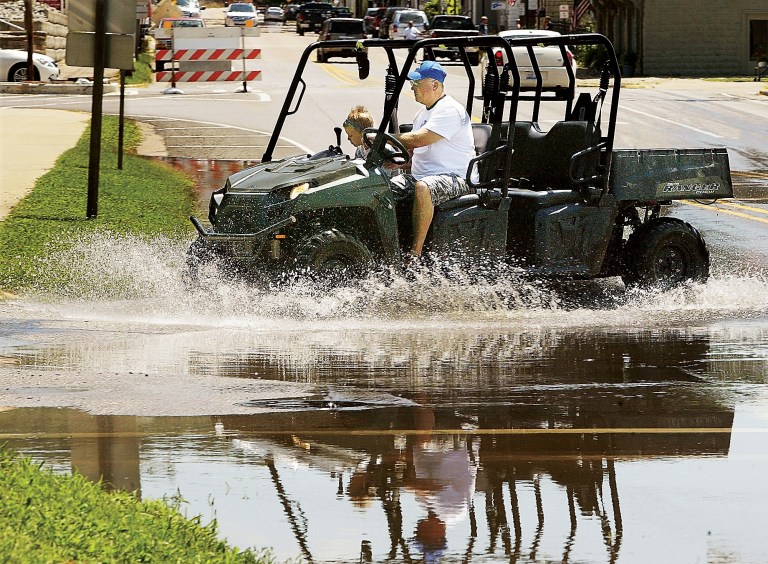 A man and a young child splash through the floodwaters covering Main Street near state Route 3 Thursday July 10, 2014, in Grafton, Ill.  Grafton sits on the confluence of the Mississippi and Illinois rivers which are expected to crest in Grafton this weekend. (AP Photo/The Telegraph, John Badman) BELLEVILLE NEWS-DEMOCRAT OUT; ST. LOUIS POST-DISPATCH OUT
