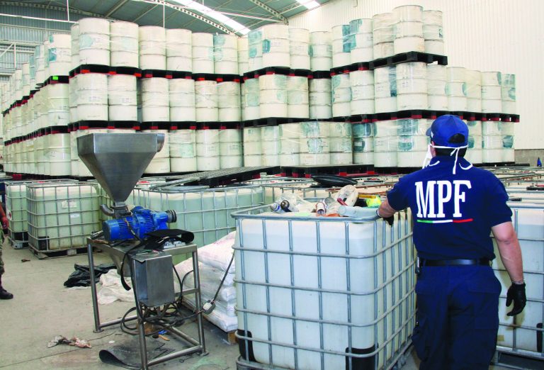 FILE - In this June 20, 2011, photo released by Mexico's Attorney General's office, police from the Federal Public Ministry looks at drums of precursor chemicals for methamphetamine that were seized in Queretaro, Mexico. Mexican drug cartels are flooding U.S. cities with cheap, extraordinarily pure methamphetamine made in factory-like 