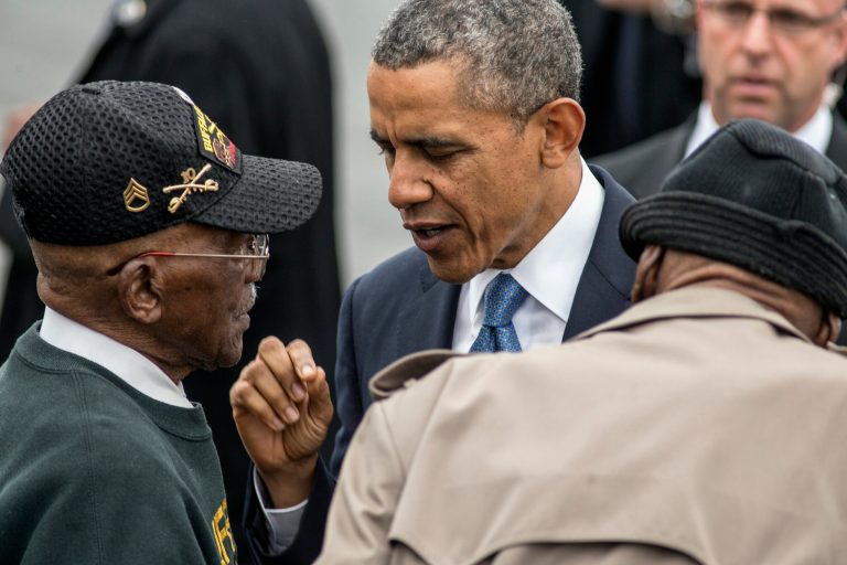 President Barack Obama talks with World War II veterans Sanders Matthews, Sr., born 1921, left, and Lewis Coffield, born 1918,  both Buffalo Soldiers, at Stewart Air National Guard Base in Newburgh, N.Y., Wednesday, May 28, 2014, after delivering the commencement address at the United States Military Academy at West Point. (AP Photo/Philip Kamrass)