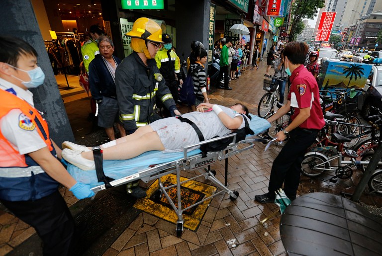 Paramedics remove a victim from a subway station exit after a knife attack on a subway in Taipei, Taiwan, Wednesday, May 21, 2014.  A drunken university student wielding a knife attacked riders aboard a subway train in Taiwan's capital on Wednesday, killing three people and injuring nearly two dozen others, police and local media said.   (AP Photo)