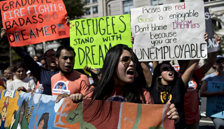 Demonstrators hold signs while protesting the end of the Deferred Action for Childhood Arrivals (DACA) program outside Trump International Hotel in Washington, D.C., U.S., on Tuesday, Sept. 5, 2017.