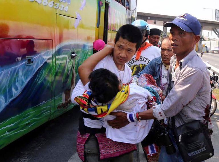 Anti-government protesters carry their injured protester from a bus to an ambulance after an attack by suspected gunmen while on their way back from a protest in Bangkok, Thailand Tuesday, April 1, 2014. Gunmen have fired on a convoy of anti-government protesters in Thailand's capital, and four people have been wounded. (AP Photo)