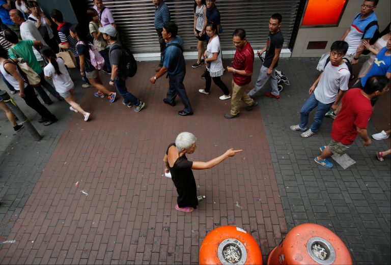 A lone woman shouts at pro-democracy student protesters blocking the streets in Mong Kok, Hong Kong, Saturday, Oct. 4, 2014. Friction between pro-democracy protesters and opponents of their weeklong occupation of major Hong Kong streets persisted Saturday as police denied they had any connection to criminal gangs suspected of inciting attacks on largely peaceful demonstrators. (AP Photo/Wally Santana)