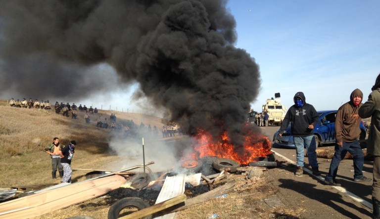 Dakota Access oil pipeline protesters burn debris as officers close in to force them from a camp on private land in the path of pipeline construction, Thursday, Oct. 27, 2016 near Cannon Ball, N.D.