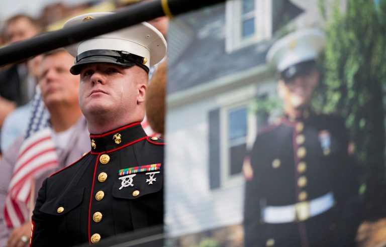 Sgt. Benjamin Tranter, a former classmate of Lance Cpl. Squire Wells, seen in photo at right, attends a memorial service for Wells at Sprayberry High School where they both attended, Tuesday, July 21, 2015, in Marietta, Ga. (AP Photo)Â 