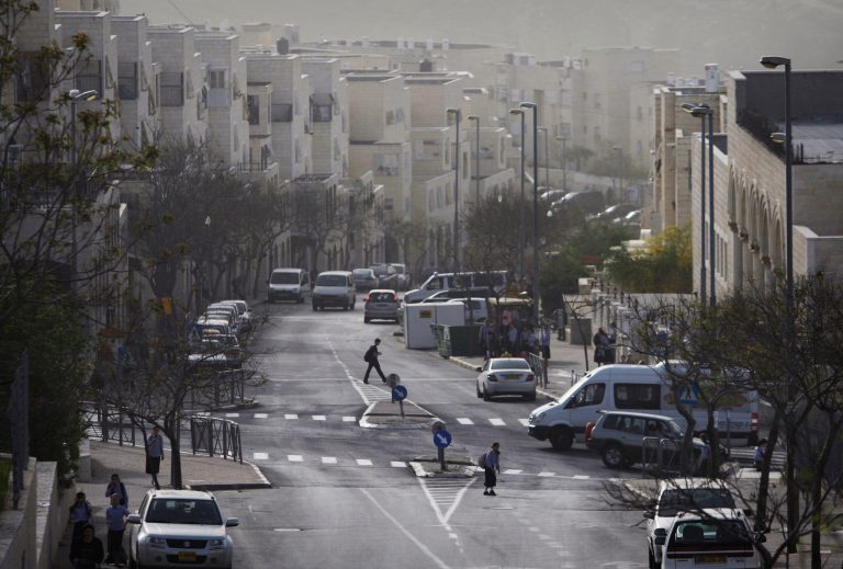 FILE - In this Wednesday, March 10, 2010 file photo, Israelis walk on a street in the east Jerusalem neighborhood of Ramat Shlomo.  Israel's housing ministry said Thursday, June 5, 2014 it was advancing plans for nearly 1,500 new settlement housing units in the West Bank and east Jerusalem in response to the new Palestinian unity government backed by the Islamic militant group Hamas. (AP Photo/Dan Balilty, File)
