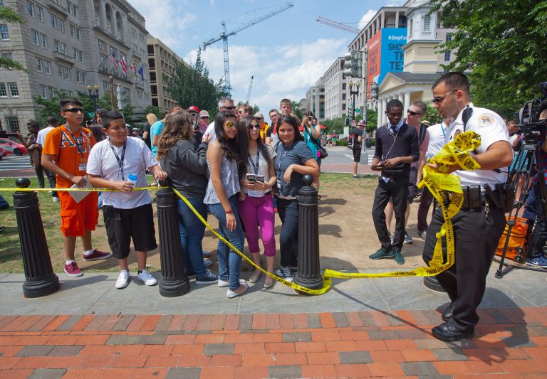A U.S. Secret Service Uniform Division officer removes police tape during the reopening of pedestrian access to Lafayette Park across from the White House in Washington, Tuesday, June 9, 2015. (AP Photo)Â 