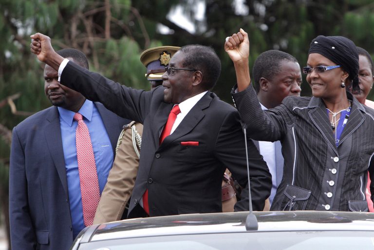 FILE - In this Sunday, Feb. 23, 2014 file photo Zimbabwe's President Robert Mugabe, left, and his wife Grace greet the crowd during birthday marking Mugabe's 90th birthday, in Marondera, Zimbabwe. She has expensive tastes, owns a lot of land in Zimbabwe and is now entering politics, a move that is roiling this southern African nation that has known only one leader since independence: President Robert Mugabe, who is 90 years old. The newcomer is Mugabe's 49-year-old wife Grace, who accepted a nomination last month to lead the ruling party's women's wing, triggering accusations that Mugabe aims to set a political dynasty in place. (AP Photo/Tsvangirayi Mukwazhi, File)