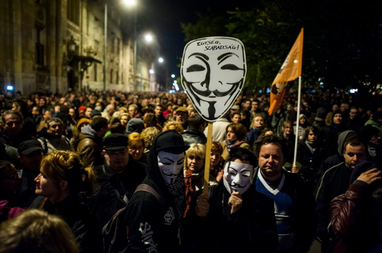 Thousands of demonstrators protest against an internet tax planned to be introduced by the Hungarian government for the second time in two days in front of the Ministry of National Economy in Budapest, Hungary, Tuesday, Oct. 28, 2014. Tens of thousands of protesters marched against a plan by the Hungarian government to tax Internet use from 2015. The inscription on Guy Fawkes mask reads: 