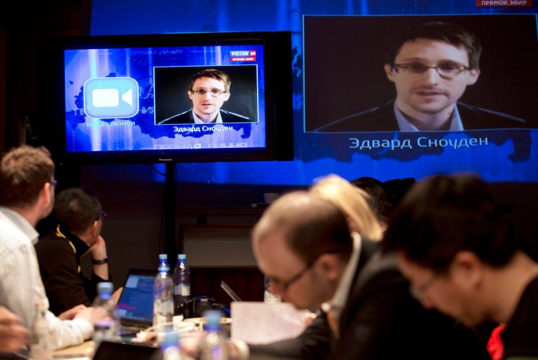 Edward Snowden, displayed on television screens, asks a question to Russian President Vladimir Putin during a nationally televised question-and-answer session, in Moscow, Thursday, April 17, 2014.  Speaking in a televised call-in show with the nation, Putin harshly criticized the West for trying to pull Ukraine into its orbit and said that people in eastern Ukraine have risen against the authorities in Kiev, who ignored their rights and legitimate demands. Putin also took a video question from National Security Agency leaker Edward Snowden, whom Russia granted asylum last year. Asked by Snowden about Russia's surveillance programs, Putin said that Russian special services also tap on communications in their fight against terrorism, but don't do it on such a massive scale as the U.S. (AP Photo/Pavel Golovkin)