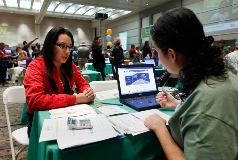 Cinthia Orozco gets help signing up for health insurance from Griselda Zamora, a health care specialist, at a health fair in Sacramento, Calif., on Nov. 9. (AP Photo/Rich Pedroncelli)