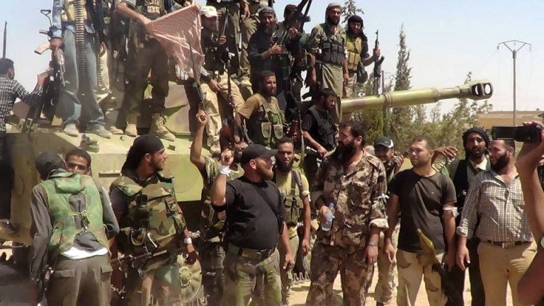 Free Syrian army fighters gather near a military tank in Idlib province, Syria, on Wednesday. (AP/Aleppo Media Center)