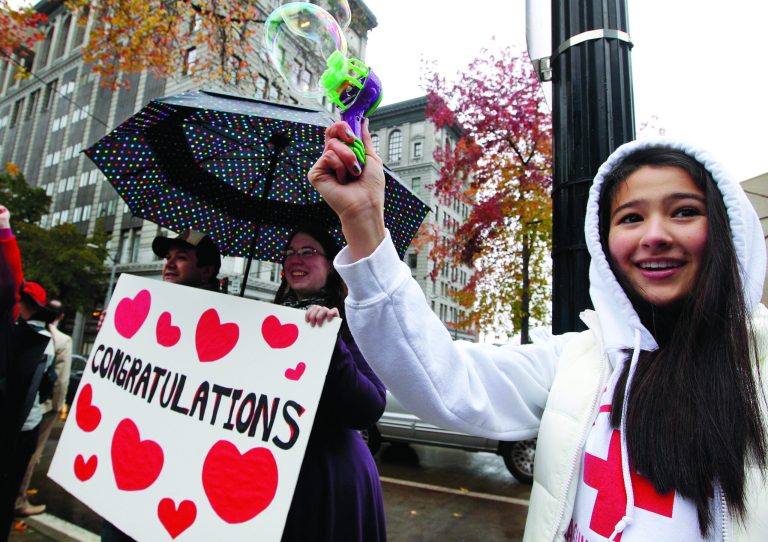 Aya Bentley, right, 14, of Bellevue, Wash., uses a small bubble-maker as she joins other well-wishers congratulating gay and lesbian newlyweds at Seattle City Hall Sunday, Dec. 9, 2012, in Seattle. Gov. Chris Gregoire signed a voter-approved law legalizing gay marriage Wednesday, Dec. 5 and weddings for gay and lesbian couples began in Washington state on Sunday, following the three-day waiting period after marriage licenses were issued earlier in the week. (AP Photo/Elaine Thompson)