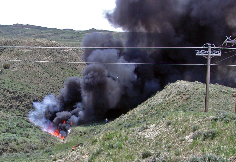 In this May 22, 2014 photo provided by the U.S. Bureau of Land Management, a 25,000-gallon oil spill burns in the Powder River Basin southeast of Buffalo, Wyo., after officials deliberately ignited the crude in what they say was their best cleanup option in the rugged area. BLM officials say a backhoe nicked the 6-inch pipe an unknown amount of time ago. They say corrosion set in at the damaged area, leading to the spill May 19. (AP Photo/U.S. Bureau of Land Management)