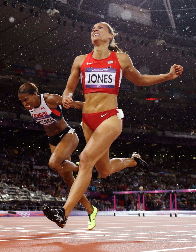 In this photo taken Tuesday, Aug. 7, 2012, United States' LoLo Jones, right, crosses the finish line to place fourth in the women's 100-meter hurdles final during the athletics in the Olympic Stadium at the 2012 Summer Olympics, London. (AP Photo/David J. Phillip)