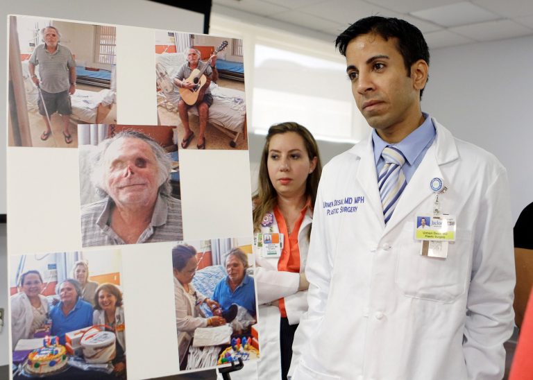Dr. Urmen Desai, right and Dr. Wrood M. Kassira, both plastic surgeons, are shown during a news conference in Miami, Tuesday, May 21, 2013. The the photos on the left are of Ronald Poppo, a homeless man whose face was mostly chewed off in a bizarre attack last year in Miami. The attack left Poppo blind, but the doctors say he's been working with an occupational therapist to learn how to take care of himself. The doctors say Poppo also has learned to play guitar and practices daily. (AP Photo/Alan Diaz)