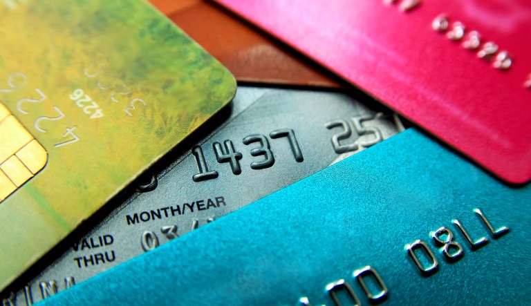 Stack of multicolored credit cards close-up view with selective focus.