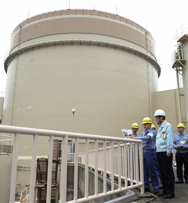   In this photo taken Tuesday, June 12, 2012, Fukui Gov. Issei Nishikawa, foreground, inspects Kansai Electric Power Co's Ohi nuclear power plant in Ohi, Fukui prefecture, western Japan. Japan moved closer Thursday, June 14, 2012 to restarting nuclear reactors for the first time since last year's earthquake and tsunami led to a nationwide shutdown after Ohi Mayor Shinobu Tokioka gave his support to a plan to bring the plant's No. 3 and No. 4 reactors back online. All 50 of Japan's workable reactors are offline because of safety concerns or for maintenance since the March 11, 2011 disaster touched off a crisis at the Fukushima Dai-ichi plant. No. 1 reactor at the plant is seen in the background. (AP Photo/Kyodo News) JAPAN OUT, MANDATORY CREDIT, NO LICENSING IN CHINA, HONG KONG, JAPAN, SOUTH KOREA AND FRANCE  
