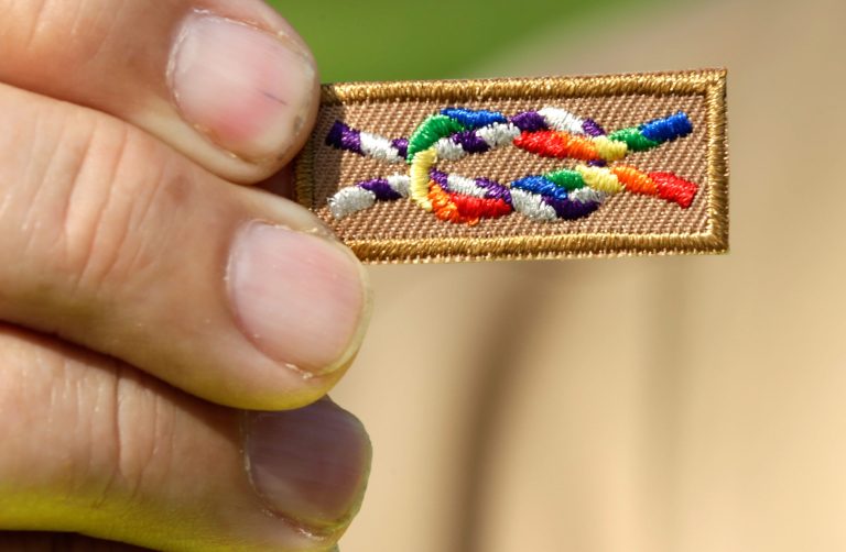 A member of Scouts for Equality holds an unofficial knot patch incorportating the colors of the rainbow, a symbol for gay rights, during a rally to call for equality and inclusion for gays in the Boy Scouts of America as part of the 'Scouts for Equality Day of Action' May 22, 2013 in Washington, D.C. (Photo by Win McNamee/Getty Images)