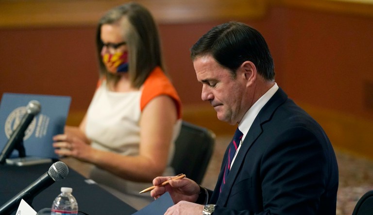 Arizona Secretary of State Katie Hobbs, left, and Arizona Gov. Doug Ducey sign election documents to certify the election results for federal, statewide, and legislative offices and statewide ballot measures at the official canvass at the Arizona Capitol Monday, Nov. 30, 2020, in Phoenix.