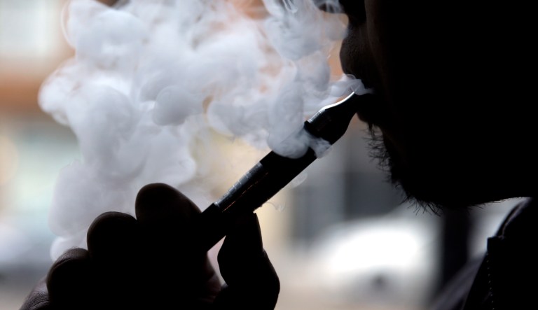 In this April 23, 2014, photo, a man smokes an electronic cigarette in Chicago.