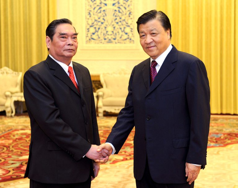In this photo released by China's Xinhua news agency, Vietnamese special envoy Le Hong Anh, left, poses with Liu Yunshan, a member of the Standing Committee of the Political Bureau of the Communist Party of China (CPC) Central Committee, prior to a meeting in Beijing Wednesday, Aug. 27, 2014. China and Vietnam said they're committed to negotiating maritime disputes to avoid a recurrence of tensions that spiked when China deployed an oil rig in waters claimed by Hanoi. (AP Photo/Xinhua, Zhang Duo) NO SALES