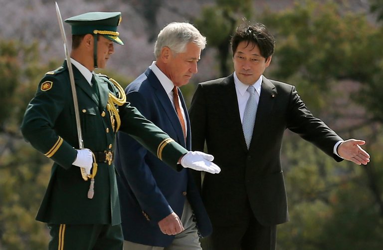 U.S. Secretary of Defense Chuck Hagel, center, is escorted by his Japanese counterpart Itsunori Onodera, right, as they inspect an honor guard at the Defense Ministry in Tokyo, Sunday, April 6, 2014. Against the backdrop of Russia's takeover of Ukraine's Crimean region, Hagel said Saturday he will convey to Japanese leaders that the U.S. is strongly committed to protecting their country's security. (AP Photo/Eugene Hoshiko)