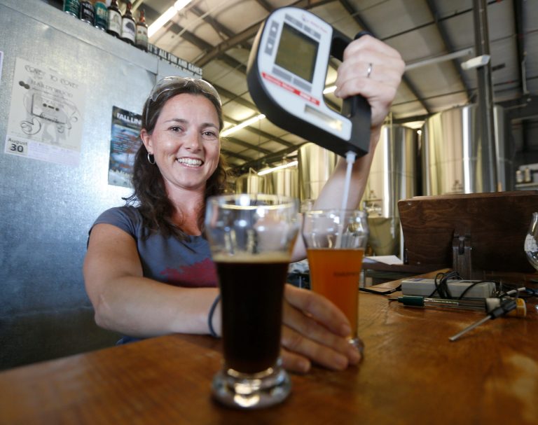 This Tuesday Aug. 26, 2014 photo shows Kate Lee, of Hardywood Park Craft Brewery, using a hydrometer to test beer samples in Richmond, Va., Tuesday, Aug. 26, 2014.  The brewery in Richmond brought in Lee, a veteran from Anheuser-Busch to head its quality assurance program. (AP Photo/Steve Helber)