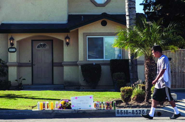 Flowers and votive candles are seen outside the home of the owners of family-owned business, United States Fire Protection Services, in Downey, Calif., Thursday, Oct. 25, 2012. A gunman killed three people and injured two, including a 13-year-old boy, Wednesday in two separate attacks on a family at its suburban Los Angeles business and nearby residence. Police in suburban Los Angeles say the five family members who were shot had been targeted by the gunman. (AP Photo/Damian Dovarganes)