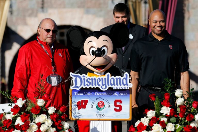   Wisconsin athletic director Barry Alvarez, left, a person dressed as Mickey Mouse, center, and Stanford head coach David Shaw pose for photos during a news conference at Disneyland in Anaheim, Calif., Wednesday, Dec. 26, 2012. Wisconsin is scheduled to play Stanford in the Rose Bowl NCAA college football game in Pasadena, Calif., on Jan. 1, 2013. (AP Photo/Jae C. Hong)  