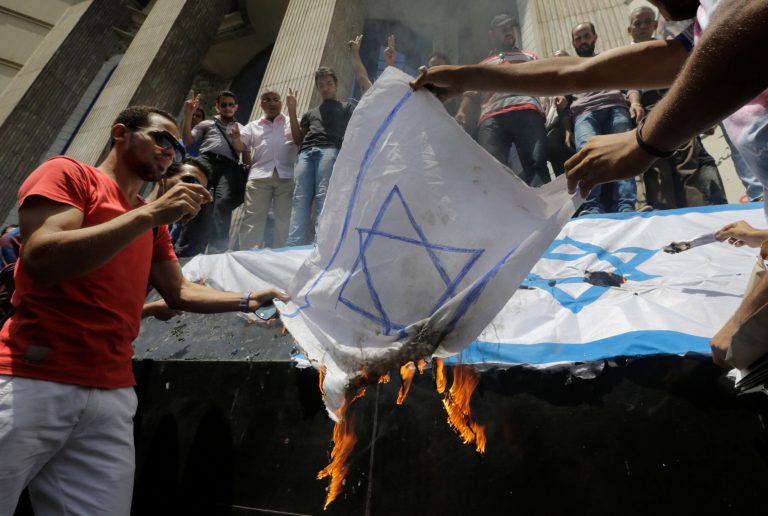 FILE - In this file photo taken Sunday, July 13, 2014, Egyptian journalists burn a representative of the Israel flag to protest against the Israeli operations in Gaza, while holding a demonstration in front of the Syndicate of Journalists building in Cairo, Egypt. In the Gaza war, the Palestinian Hamas is demanding the opening of Egypt's Sinai border crossing into blockaded Gaza, but Egypt is so far staunchly refusing _ a reflection of its sharp rivalry with Hamas, which it accuses of fueling militancy on its soil. (AP Photo/Amr Nabil, File)