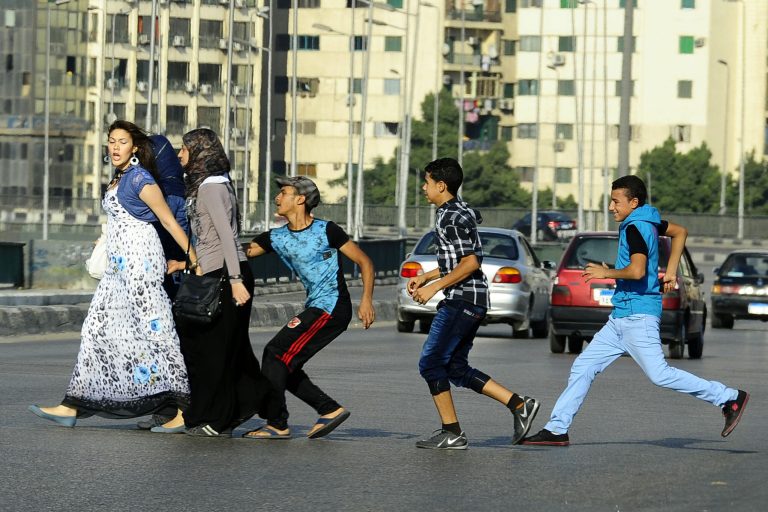 FILE -- In this Monday, Aug. 20, 2012 file photo, an Egyptian youth, trailed by his friends, gropes a woman crossing the street with her friends in Cairo, Egypt. Abdel-Fattah el-Sissi, Egypt's newly sworn-in president, has apologized in person to a woman who was sexually assaulted by a mob during weekend celebrations marking his inauguration. Several women were assaulted during the Sunday, June 8, 2014 inaugural festivities. (AP Photo/Ahmed Abd El Latif, El Shorouk Newspaper, File)   EGYPT OUT