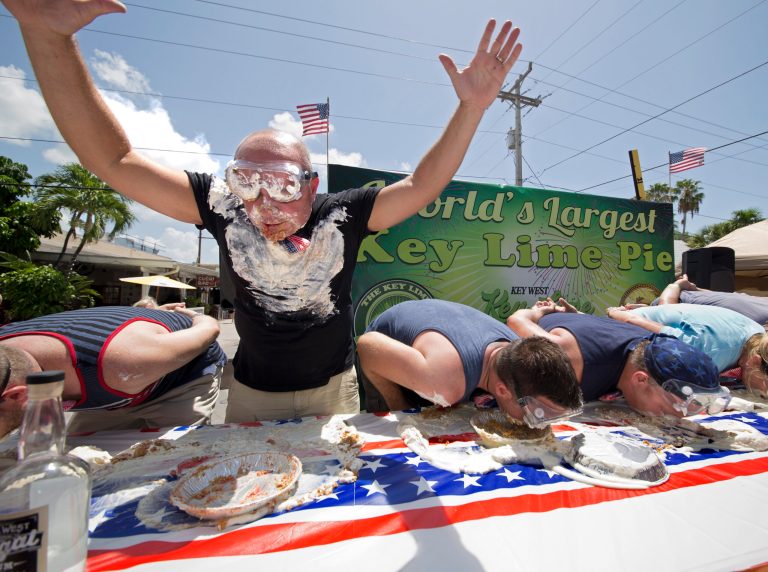 In this photo provided by the Florida Keys News Bureau, Tony Mantia raises his hands to signal he is the first contestant to finish consuming a full pie during the Key Lime Pie Eatin' Contest, Friday, July 4, 2014, in Key West, Fla. The event was staged during the Key Lime Festival that continues through Saturday, and features several events including the creation of the world's largest Key lime pie and a Miss Key Lime Pageant. (AP Photo/Florida Keys News Bureau, Rob O'Neal)