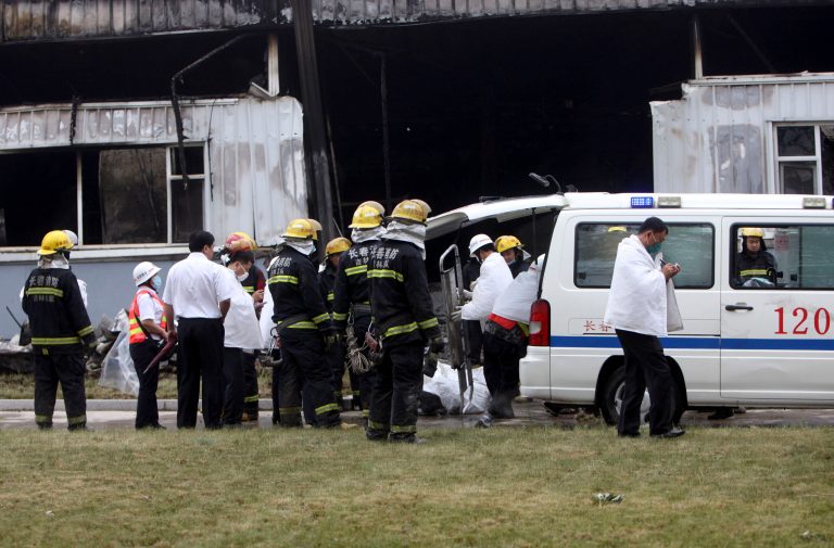 Firefighters and medical staff prepare to remove body bags that appears to contain the bodies of those killed by a fire at a poultry processing plant in northeast China's Jilin province's Mishazi township on Monday, June 3, 2013. The massive fire broke out at the poultry plant early Monday, trapping workers inside a cluttered slaughterhouse and killing over a hundred people, reports and officials said. (AP Photo) CHINA OUT