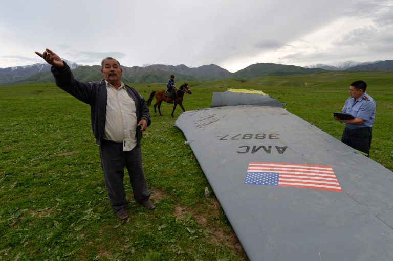 A Kyrgyz policeman investigates a U.S. Air Force KC-135 tanker aircraft wreckage as a local citizen speaks to The Associated Press photographer on a field near the village of Chaldovar, about 100 miles (160 kms) west of the Kyrgyz capital Bishkek, Friday, May 3, 2013. The emergencies ministry in Kyrgyzstan says a US military plane has crashed in the country. Kyrgyzstan hosts a US base that is used for troops transiting into and out of Afghanistan and for C-135 tanker planes that refuel warplanes in flight. (AP Photo/Vladimir Voronin)