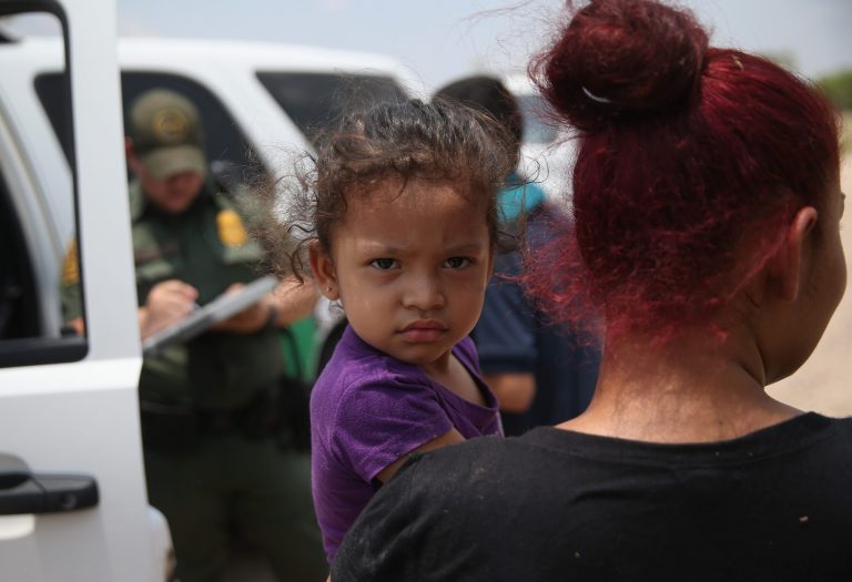 A mother and child, 3, from El Salvador await transport to a processing center for undocumented immigrants after they crossed the Rio Grande into the United States on July 24, 2014 in Mission, Texas. (Photo by John Moore/Getty Images