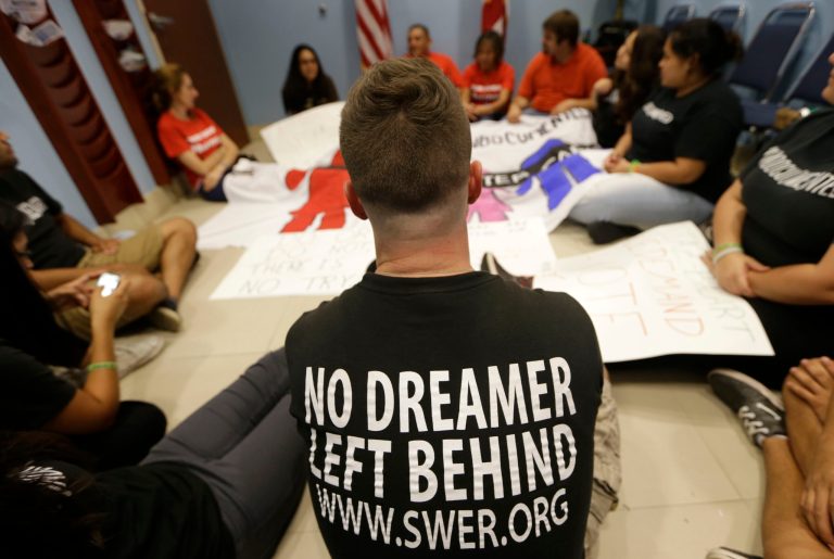 Geoff Robbins, 24, center, sits on the floor with other activists in support of immigration reform during a protest at the office of Congressman Mario Diaz-Balart, R-Fla., on Friday in Miami. (AP Photo/Lynne Sladky)