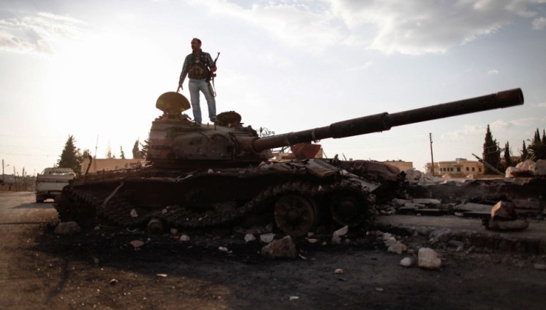 A Free Syrian army fighter stands on a damaged military tank in Zabadani, near Damascus on Sunday. (AP Photo/The Syrian Revolution against Bashar Assad)