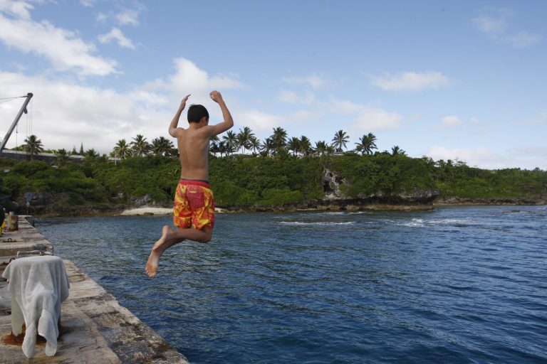 In this Wednesday, June 4, 2014 photo, a boy jumps from a wharf in Alofi, Niue. Severe population decline on the tiny Pacific atoll is threatening a culture that dates back more than 1,000 years. (AP Photo/Nick Perry)