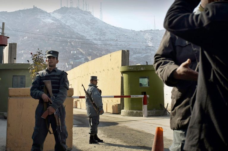   FILE - In this Monday, Dec. 24, 2014 file photo, Afghan police officers stand guard outside of Kabul police headquarters, where a an American contractor was killed, in Kabul, Afghanistan. On Tuesday, Dec. 25, 2012, the Interior Ministry said a policewoman, identified as Sgt. Nargas, who shot and killed 49-year-old Joseph Griffin in Kabul on Monday, was a native Iranian who came to Afghanistan and displayed 